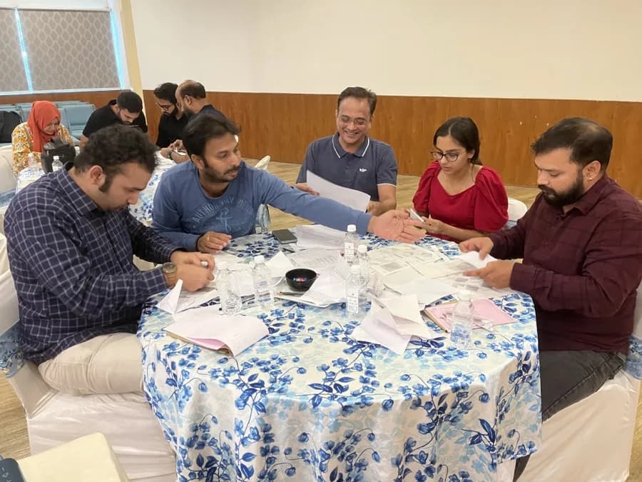 FusionFoundry team collaborating around a table during a workshop exercise